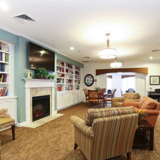 A cozy living room with a fireplace, bookshelves, and comfortable seating.