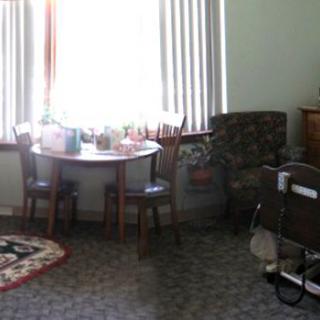 A cozy living room with a small table and chairs near a window.