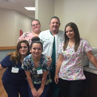 A dedicated healthcare team posing together in a hospital setting.