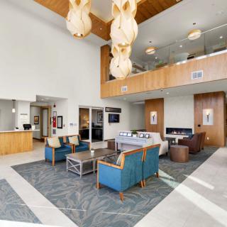 A spacious and modern lobby featuring comfortable seating, stylish lighting fixtures, and a welcoming atmosphere.
