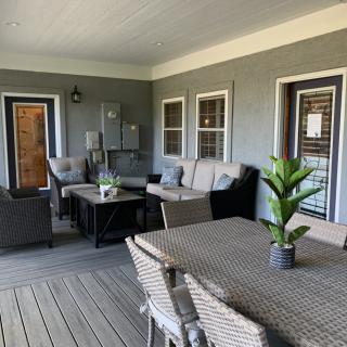 A cozy outdoor patio with comfortable seating and a table, ideal for relaxation.