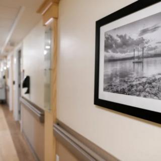 A hospital hallway featuring framed artwork on the wall.
