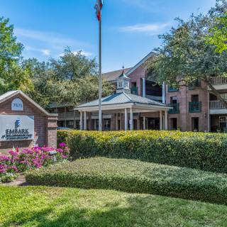 A well-maintained hotel exterior with landscaped gardens and a prominent sign.