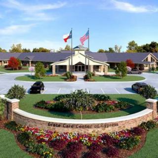 A well-maintained facility with a circular driveway, landscaped gardens, and flags flying at the entrance.