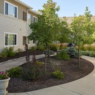A well-landscaped apartment complex with a garden and pathway.