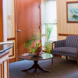 Cozy waiting room with a sofa, table, and decorative plants.