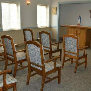 A small chapel with several chairs arranged facing an altar.