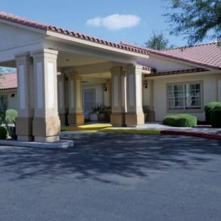 A building entrance with columns and a driveway.