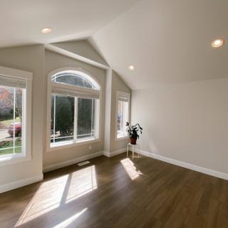 A spacious and bright living room featuring large windows that invite natural light.