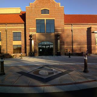 A modern brick building featuring a welcoming entrance and well-maintained landscaping.