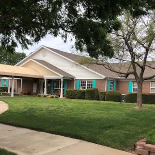 A suburban house with a well-maintained lawn and a driveway leading to the entrance.