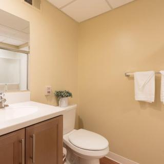 A minimalist bathroom with a sink, toilet, and mirror.