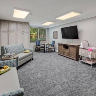 A cozy, modern living room with a sofa, television, and dining table.