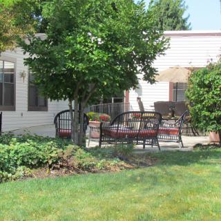 A peaceful backyard patio with seating and greenery.