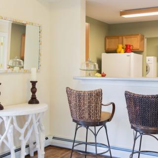 A cozy apartment kitchen with bar stools and home decor accents.