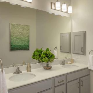 A modern bathroom vanity with double sinks, mirrors, and elegant lighting.