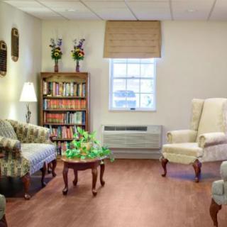 A cozy living room with comfortable seating, a bookshelf filled with books, and a coffee table centered in the room.