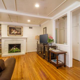 A cozy living room with a fireplace, TV, and hardwood flooring.