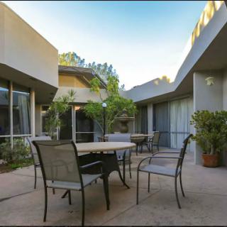 A serene outdoor courtyard featuring modern seating and lush greenery, perfect for relaxation.
