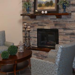 A cozy living room with a stone fireplace, plush seating, and elegant decor.