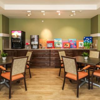 A cozy breakfast area with tables, chairs, and beverage machines.