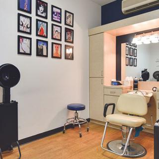 A cozy hair salon interior with a styling chair and wall decorations.