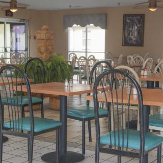 An empty restaurant dining area with neatly arranged tables and chairs.