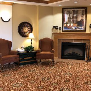 A cozy living room with a fireplace, two armchairs, and elegant decor.