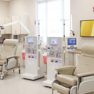 A modern dialysis clinic equipped with medical machines and comfortable chairs.