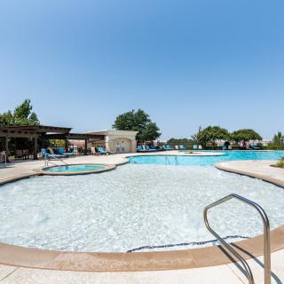 An inviting outdoor swimming pool under a clear blue sky, perfect for summer relaxation.