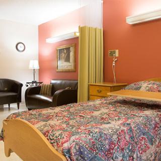 A cozy hotel room featuring a bed, seating area, and warm decor.
