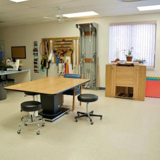 A well-equipped physical therapy room with a central therapy table and various rehabilitation tools.