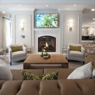 A modern living room with a cozy fireplace, stylish seating, and elegant decor.