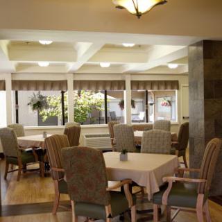 A cozy dining area filled with comfortable seating and large windows allowing natural light to illuminate the space.