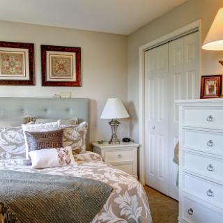 A cozy and stylish bedroom featuring elegant furniture and decorative artwork.