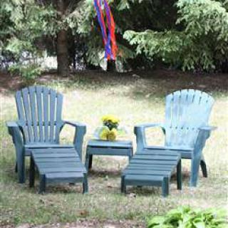 A cozy outdoor seating area with two chairs and a table, set in a lush garden.