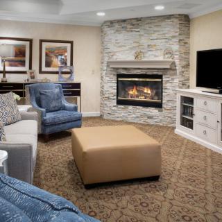 A modern living room featuring a stone fireplace and comfortable seating.