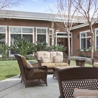A cozy outdoor patio with comfortable seating and garden surroundings.