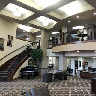 A spacious and modern lobby with a staircase and comfortable seating area.