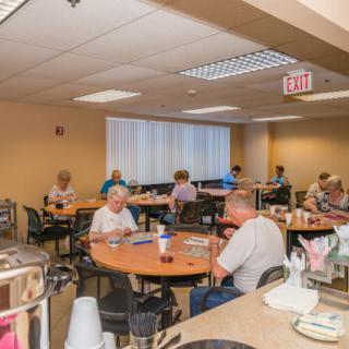 Elderly individuals dining in a casual, indoor setting.