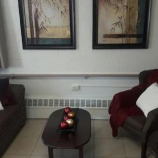 A cozy living room setup with two chairs, a coffee table, and framed artwork on the wall.
