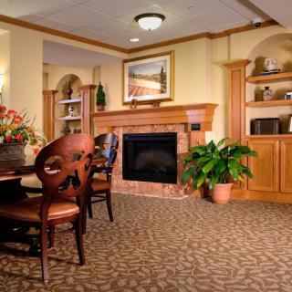 A cozy living room featuring a fireplace, dining table, and surrounding decor.