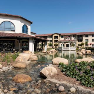 A serene view of a modern resort featuring elegant architecture and tranquil landscaping.