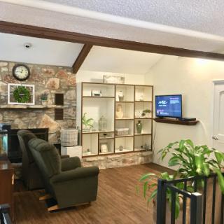 A cozy living room featuring comfortable seating, elegant shelves for display, and a modern television.