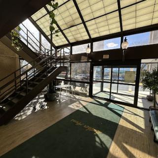 A bright and inviting lobby featuring a staircase, abundant natural light, and greenery.