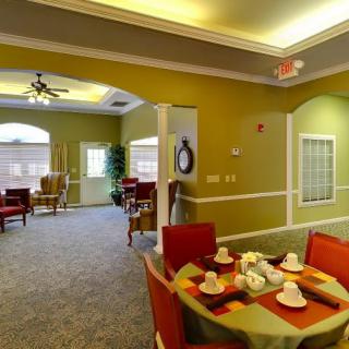 A cozy interior featuring a dining area with a neatly set table and comfortable living space in the background.