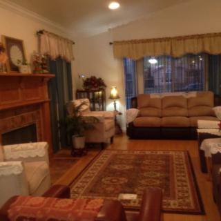 A cozy living room with warm lighting, featuring a sofa, fireplace, and decorative elements.
