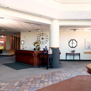 A well-lit office lobby with a reception desk and decorative elements.