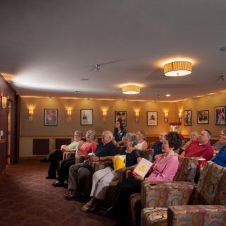 A group of people seated in a theater, watching a movie.