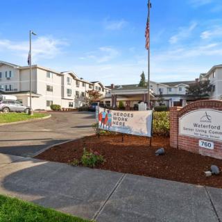 Exterior view of a senior living facility with visible signage and landscaping.